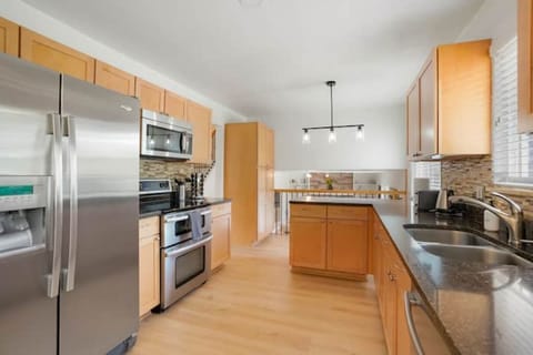 Open concept style view from kitchen towards balcony toward mezzanine fmly room