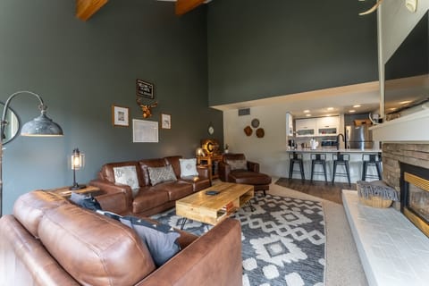 Living area offering cozy furnishings, valued ceilings and a gas fireplace.