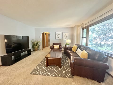 Living room with leather sofas and 70 inch smart TV 