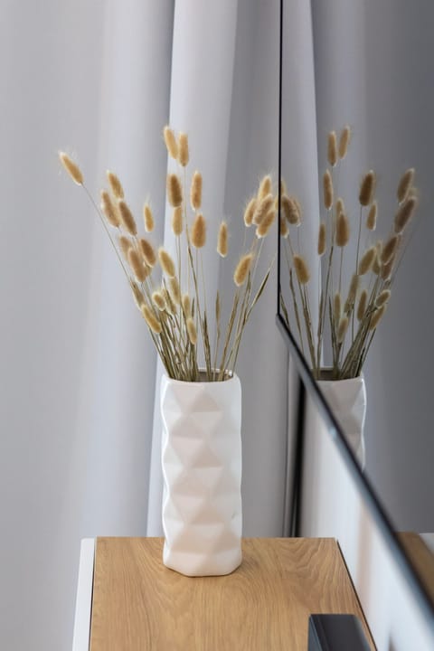A simple vase with dried reeds, adding a natural decorative element to the bright interior.





