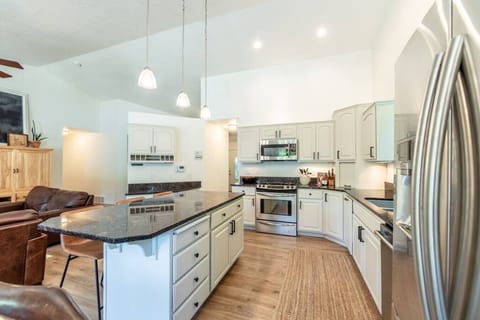 Fully stocked kitchen offering large island, granite counter tops, SS appliances, gas range