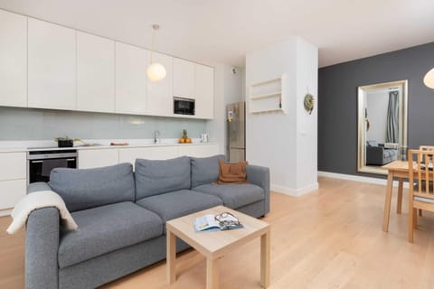 A modern living room with a grey sofa, wooden coffee table, and a clean open-plan layout.
