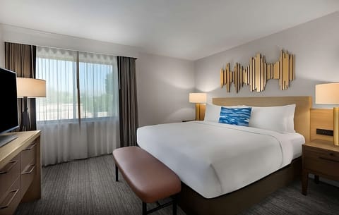 Unwind in a serene king bed with bright window views.