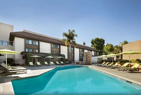 Soak up the sun beside a sparkling pool and umbrellas.