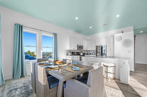 Upstairs kitchen and formal dining area with seating for six at the dining table and two at the bar