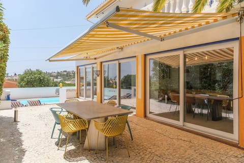 The patio with outdoor dining that sets 8-10 and a view of the pool.