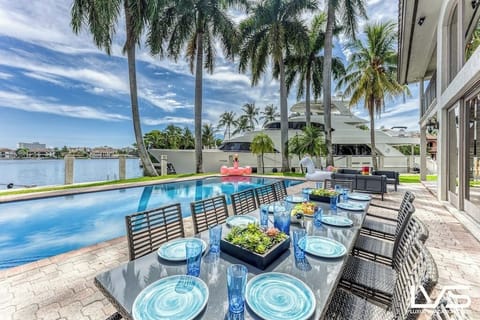 Outdoor waterfront Point Lot with pool area with outdoor dining, lounge chairs, BBQ & siting area.