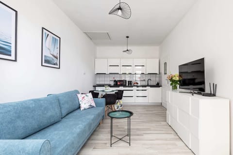 A well-lit living and dining area with a spacious layout and minimalistic furnishings.

