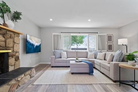 Bright and spacious living room with sectional sofa, fireplace, and smart TV — perfect for relaxing together.