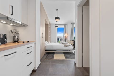 Inviting hallway with modern lighting, leading to a cozy bedroom and living area.