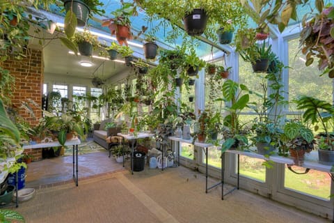 Climate controlled greenhouse with seating, TV, and freshwater aquarium.