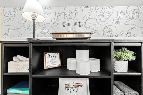 Bathroom cubby includes extra toilet paper, tissue paper, and a nightlamp