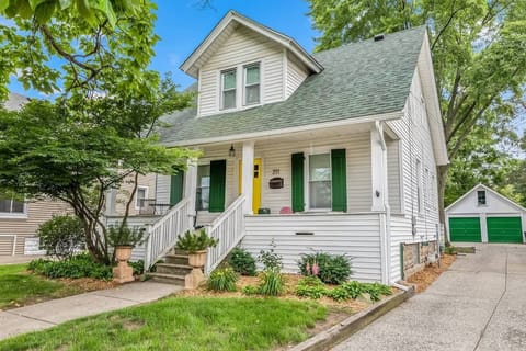 The entrance of the house adorned with a vibrant yellow door complemented by refreshing green window panels.