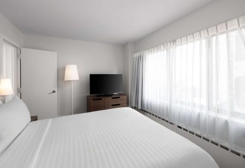 Wake refreshed in a calm room with oversized windows.