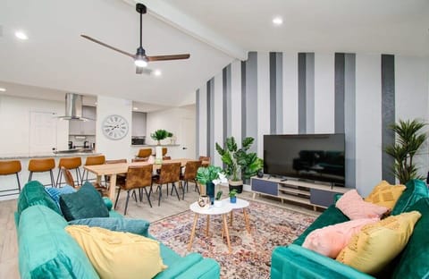 This spacious open-concept living space features high-vaulted ceilings, plenty of natural sunlight, and lots of space for socializing in both the dining and the living area.