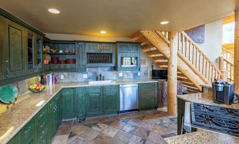 Well stocked kitchen with high-end appliances overlooking living and dining area.