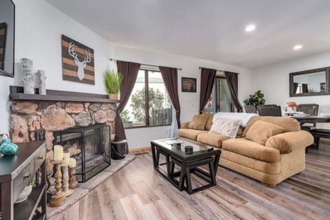 A cozy rustic stone fireplace with cabin decor make this a perfect spot to gather around  with family and friends with a nice comfortable sofa and large dining area and a view to the deck outside.  This retreat is just steps to Boulder Bay.