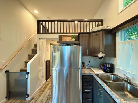 Kitchen with full size appliances, utensils, cookware and a baby safety gate.