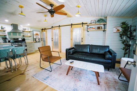 Open concept living, kitchen and dining room with comfy couch and retro table