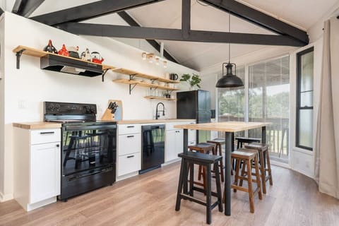 Open kitchen and dining area with modern touches, vaulted ceilings, and seating for four.