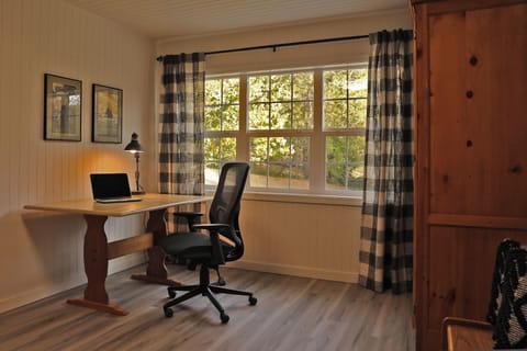 Work from home office with lamp, ergonomic chair and a door for privacy.