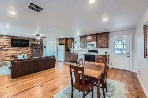 Enjoy an open-concept layout with a fully equipped kitchen, dining area, and living room accented by warm wood finishes