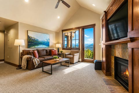 Bright living room with private balcony & fireplace.