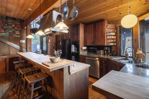 Kitchen features an island with barstool seats.