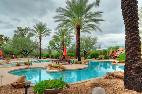 Lounge by crystal-blue water with tranquil garden views.