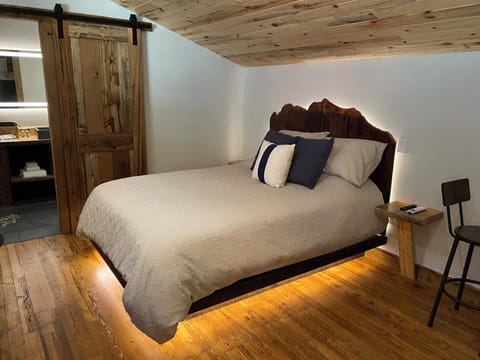 Queen bed with handmade barnwood headboard and LED lighting.