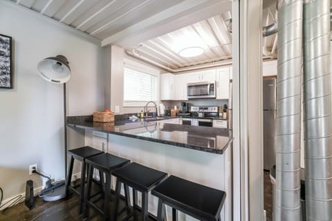 View of kitchen from living area including bar seating for meals