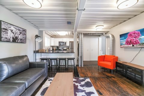 View of kitchen from living area. Note 55"smart TV on the right over a console that contains games and cards for your leisure.