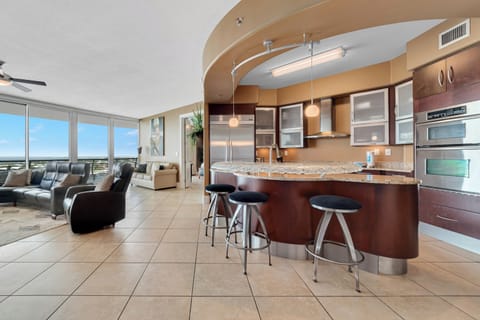 Gourmet kitchen with stainless steel appliances, granite countertops, and island seating. Open floor plan seamlessly connects to the living and dining areas.