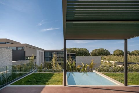 The pool lies in the lush gardens