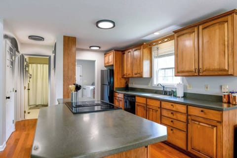 Culinary dreams come true in this spacious kitchen, boasting a grand counter, wooden cabinets, and a roomy sink area.