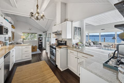 Step into a modern culinary masterpiece, where the pure elegance of white takes center stage in a beautifully designed kitchen.