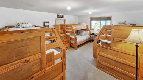 A dynamic basement bedroom boasts three twin-over-queen bunk beds as well as a work space and a play area.