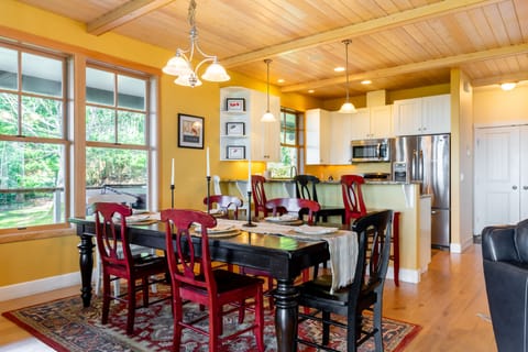 Large windows flank the dining space, inviting natural light to pour in and allowing a glimpse of the outdoor beauty.