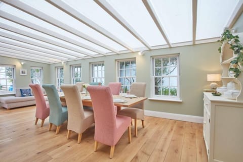 Tamarisk House, Newquay. Ground floor: Dining room with seating for ten guests, a corner sofa and Smart television