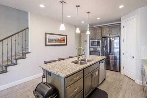 Kitchen Island - Side view of kitchen showing off the beautiful counter tops and stainless-steel appliances.