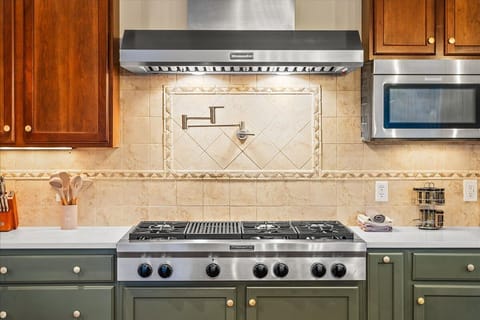 Fully stocked kitchen featuring stainless steel appliances, and quartz countertops, including a dishwasher, microwave, gas cooktop, and double ovens