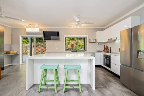 The kitchen island has stools for additional casual dining and a TV so you can enjoy music, or perhaps follow along a cooking show. Large glass doors and windows face towards the backyard bringing in pleasant light and air. 
