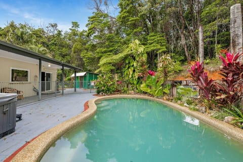 In the backyard a large bean-shaped pool is the perfect way to cool down and relax on a summer's day. The pool is lined with lush plant life providing a natural privacy screen and tropical vibe. 
