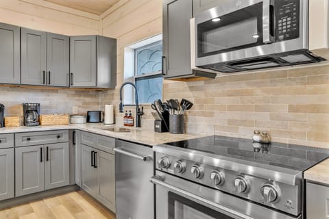 Fully equipped chef’s kitchen with granite countertops and bar seating.