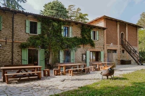 stone front facade with outdoor tables, fire pit and stairs to the charming barn