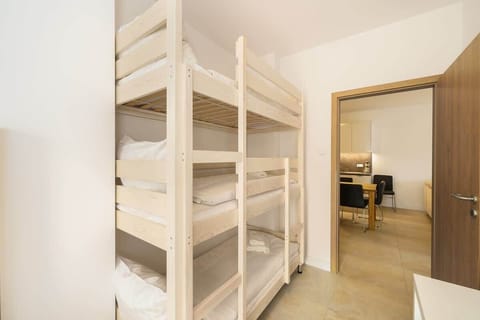 A bedroom with bunk beds and a simple, functional design, ideal for maximizing sleeping arrangements in a compact space.