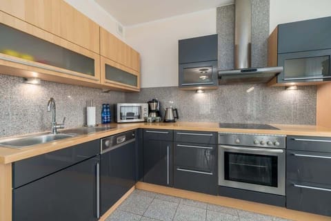 Another angle of the kitchen, showing dark cabinets, a backsplash, and ample counter space.