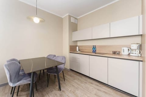 A dining area with a modern table, chairs, and a pendant light, designed for comfort and style.