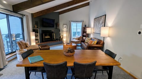 Living room with dining table, wood fireplace, and balcony w/ propane BBQ grill