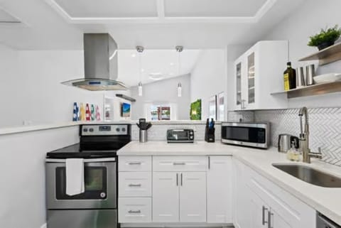 This fully equipped kitchen boasts sleek base cabinets and a modern range hood